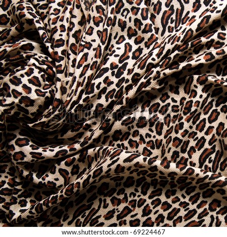 Close-up of a folds of stylish leopard scarf (cashmere background with a predatory pattern).