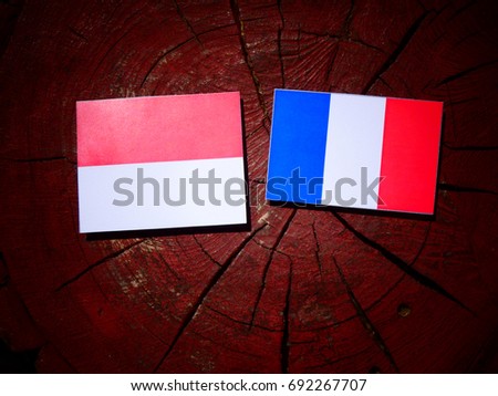 Monaco flag with French flag on a tree stump isolated