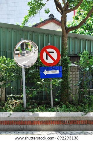 Traffic direction sign and convex mirror. "Exit" in Chinese word on the ground. 