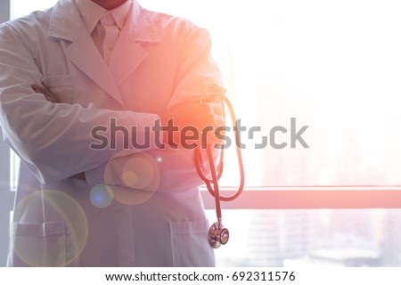 Professional medical physician doctor in white uniform gown coat hand holding stethoscope in clinic hospital.Medical/ healthcare/ technology concept Royalty-Free Stock Photo #692311576
