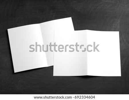 Identity design, corporate templates, company style, set of booklets, blank white folding paper flyer on a black chalkboard.