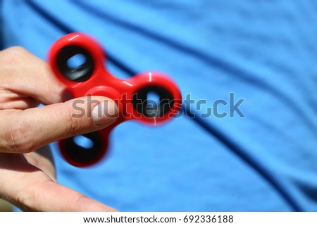 Happy man holds spinner spin antistress toy in hand for fun and time killer