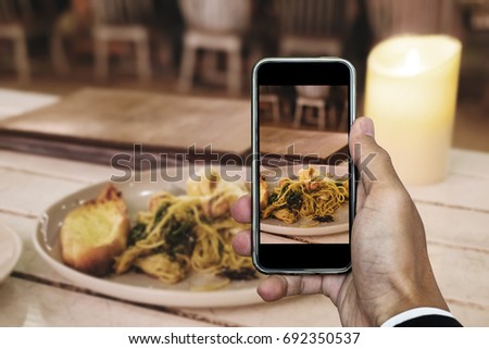 Taking food photo, dinner food photography by smart phone, seafood spaghetti under candle lights