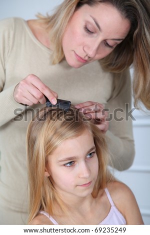 Mother treating daughter's hair against lice