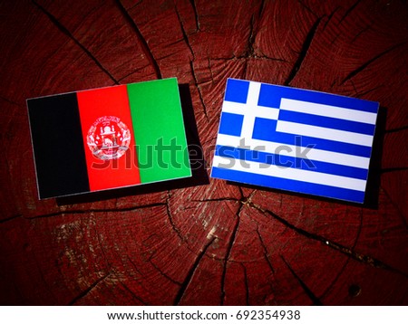 Afghanistan flag with Greek flag on a tree stump isolated