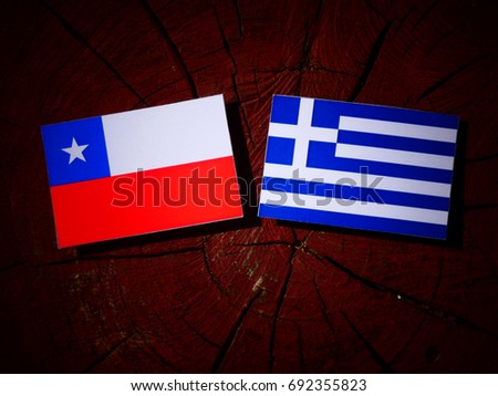 Chilean flag with Greek flag on a tree stump isolated