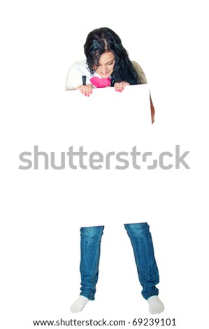Full length portrait of a beautiful young female holding empty board and looking at it against white background