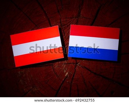 Austrian flag with Dutch flag on a tree stump isolated