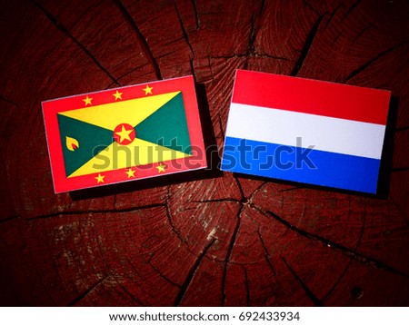 Grenada flag with Dutch flag on a tree stump isolated