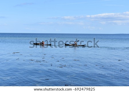 People kayaking in the sea , with beautiful sky background. 