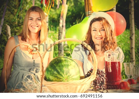 Two beautiful happy middle-aged women at a picnic celebrate. instagram image filter retro style