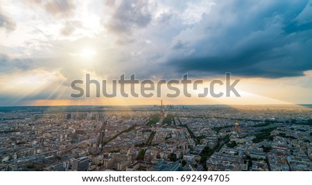 panormaic picture of paris areal view, the eiffel tower and dramatic clouds with sun rays in the evening