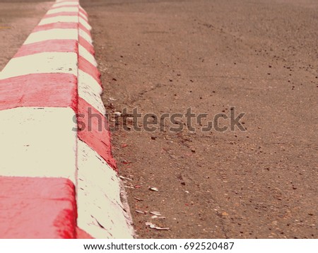 Red and white kerb. Warning construction on roadside