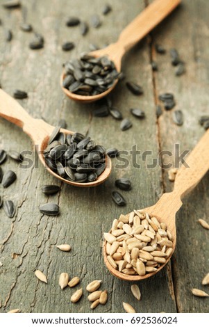 Sunflower seeds in spoons on wooden table