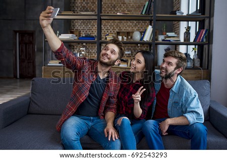 Photo for memory. Three hipster friends make a selfie, smiling and gesturing with a sign of victory.