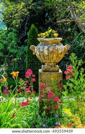 Concrete flower pots in the garden on a pedestal stylized antique, a place of rest, practical urban, flowerpot