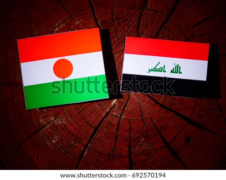 Niger flag with Iraqi flag on a tree stump isolated