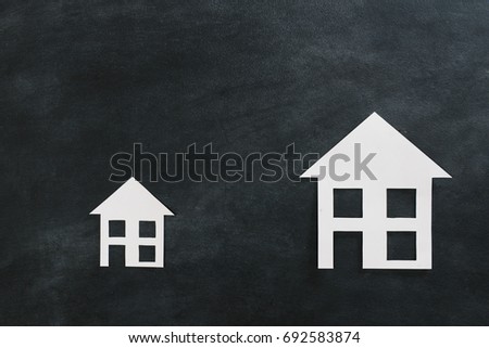 high angle view photo of estate investment advertising with two different size paper house model isolated on black chalkboard background.