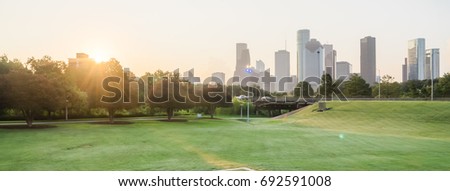 Panorama view of downtown Houston from Police Memorial park at sunrise with sunbeam/light ray. Green park lawn and modern skylines. The most populous city in Texas, and fourth-most in United States.