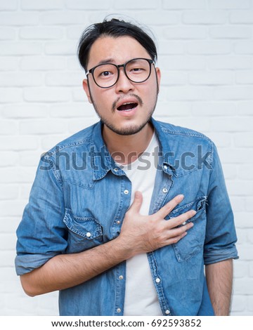 Asian young man having heart attack- close up portrait asian nerdy man