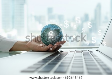 digital economy and income online concept. global on hand with network revenue dollar money icon and laptop computer.