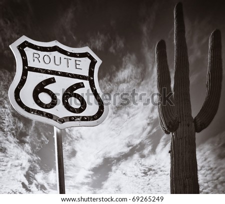 Route 66 road sign with Saguaro Cactus and wild dramatic sky Royalty-Free Stock Photo #69265249