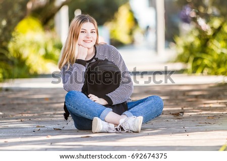 outdoor portrait of young happy smiling teen girl on natural background on a sunny day