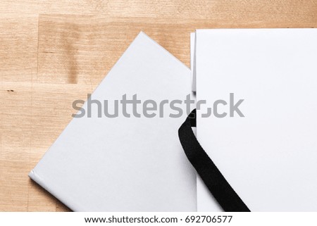 White blank clean book in paper bag mock up on wooden table background