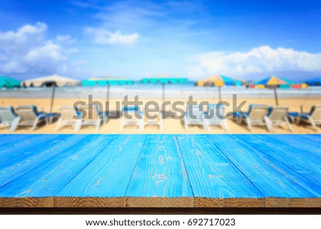 Empty top of blue wooden table or counter and view of tropical beach background. For photo montage or product display