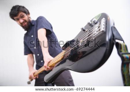 Rocker smashing guitar, white background