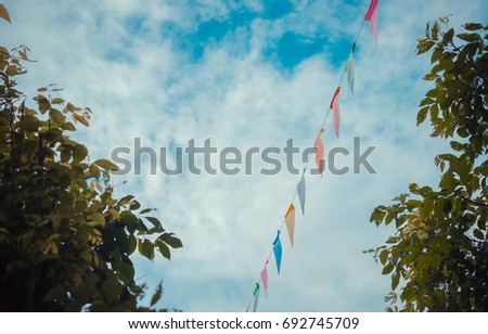 vintage tone image of festival flag line with blue sky in background on day time .