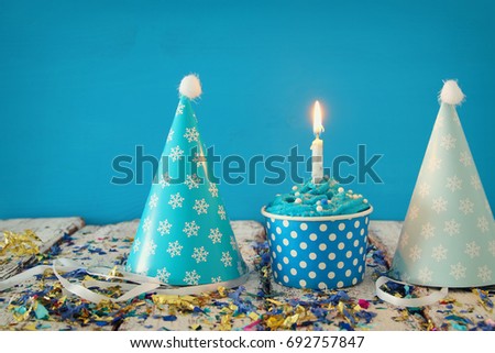 Birthday concept with cupcake and candle on wooden table.