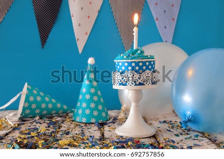 Birthday concept with cupcake and candle on wooden table.