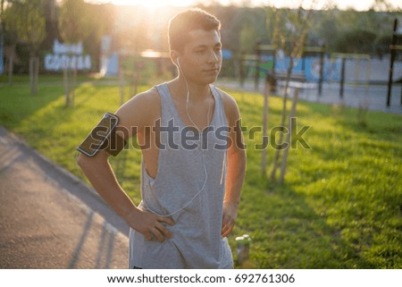 A young guy is doing sports Warm-up in the park