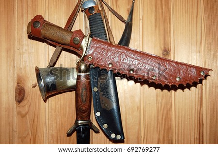 Hunting knives on the background of a wooden wall