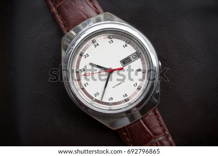 Retro men wrist watch on dark leather background.Old men wrist watch