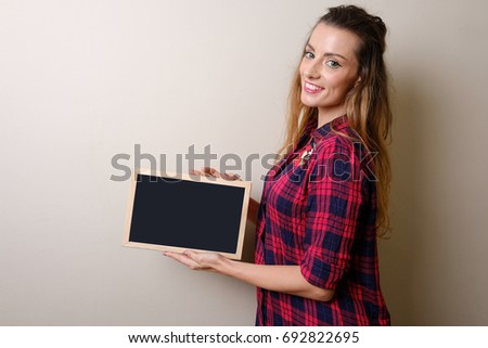 Pretty woman holding blank blackboard