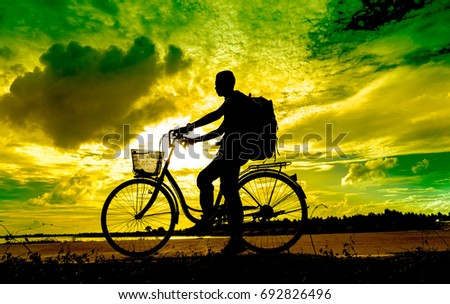 Silhouette of cyclist in motion on the background of beautiful sunset.
