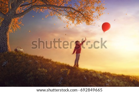 Cute little happy girl walking in autumn Park. Pretty child enjoys the beautiful autumn nature. Kid playing with air balloon.