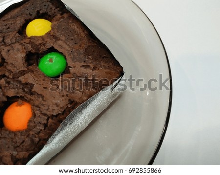Chocolate cake with yellow candy, green candy, orange candy Place it on top of the cake in a glass dish