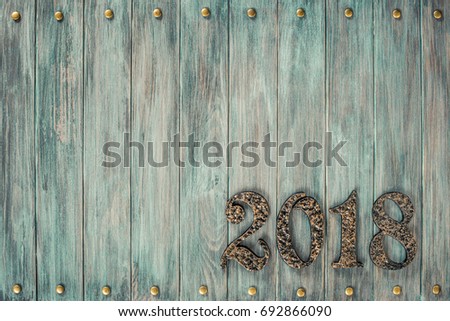 Metal forged 2018 date on vintage old mint green painted wooden wall planks texture background. Retro style filtered photo