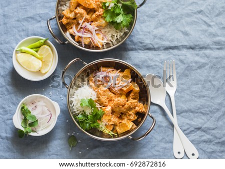 Vegetarian potato and cauliflower curry with rice in curry dishes on a blue background, top view. Vegetarian healthy food concept. Flat lay    Royalty-Free Stock Photo #692872816