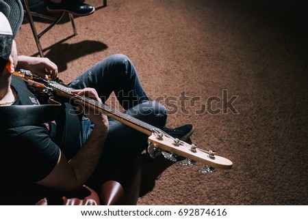 Bass guitar top view. Music background. Unrecognizable guitarist playing string instrument in studio