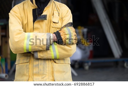 Firefighter crosss arm person who try to stop fire by extinguisher in firefight.