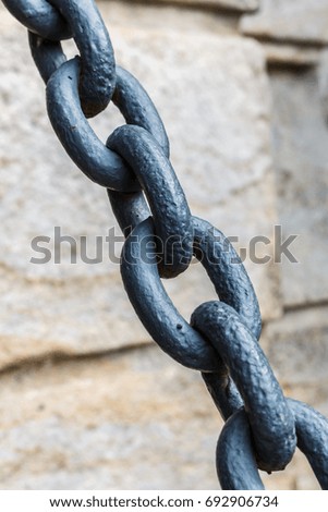 Old metal chain on a old wall background. Close up.