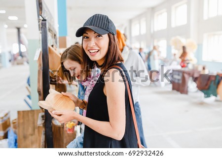 Woman shopping at the indoor handmade market Royalty-Free Stock Photo #692932426