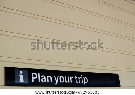 Information sign "Plan your trip" on the white wall.