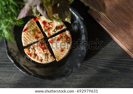 Homemade cheese with spices. Preparation of homemade cheese. Goat cheese with olive oil, spices, herbs on a dark background.