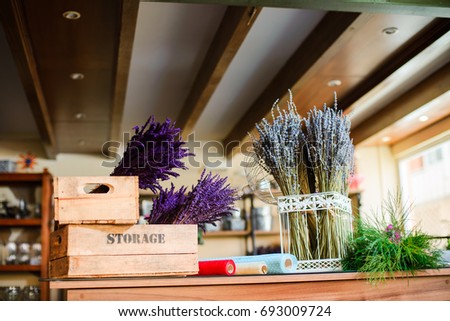 Lavender flowers bouquets in a white metal cage and wooden box at a flower shop. Delivery of flowers. Creative floral sturio.