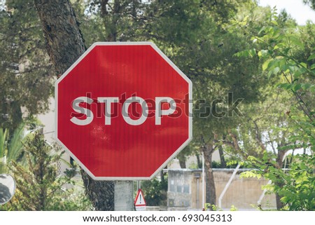 red stop sign at spain with green background